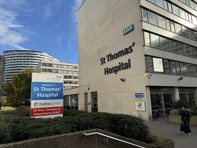 Exterior of St Thomas' Hospital building with clear signage and a blue sky background.